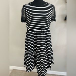 Loose-fitting casual black and white dress with lace sleeves and cutout back